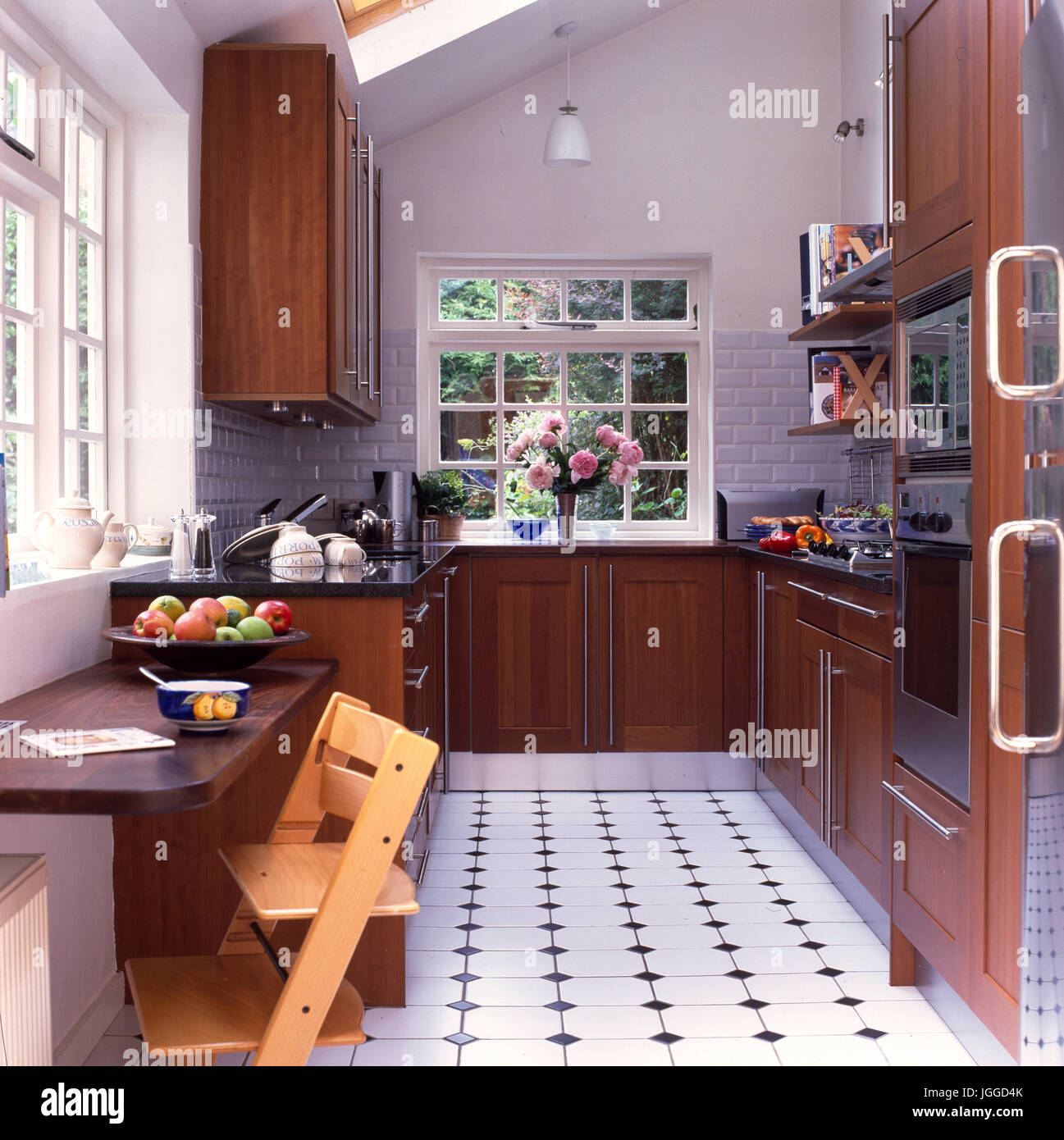 Modern wooden kitchen with black & white tiled floor Stock Photo