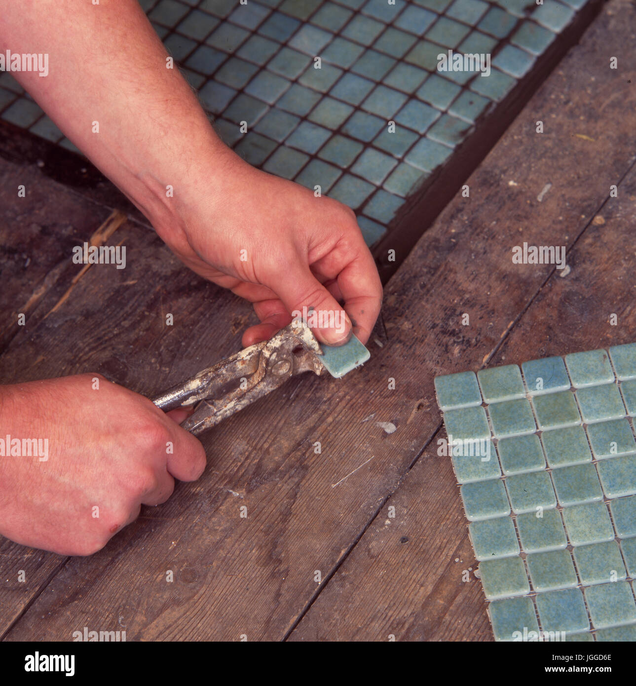 Renovating fireplace and hearth: Fitting mosaic tile sheets Stock Photo