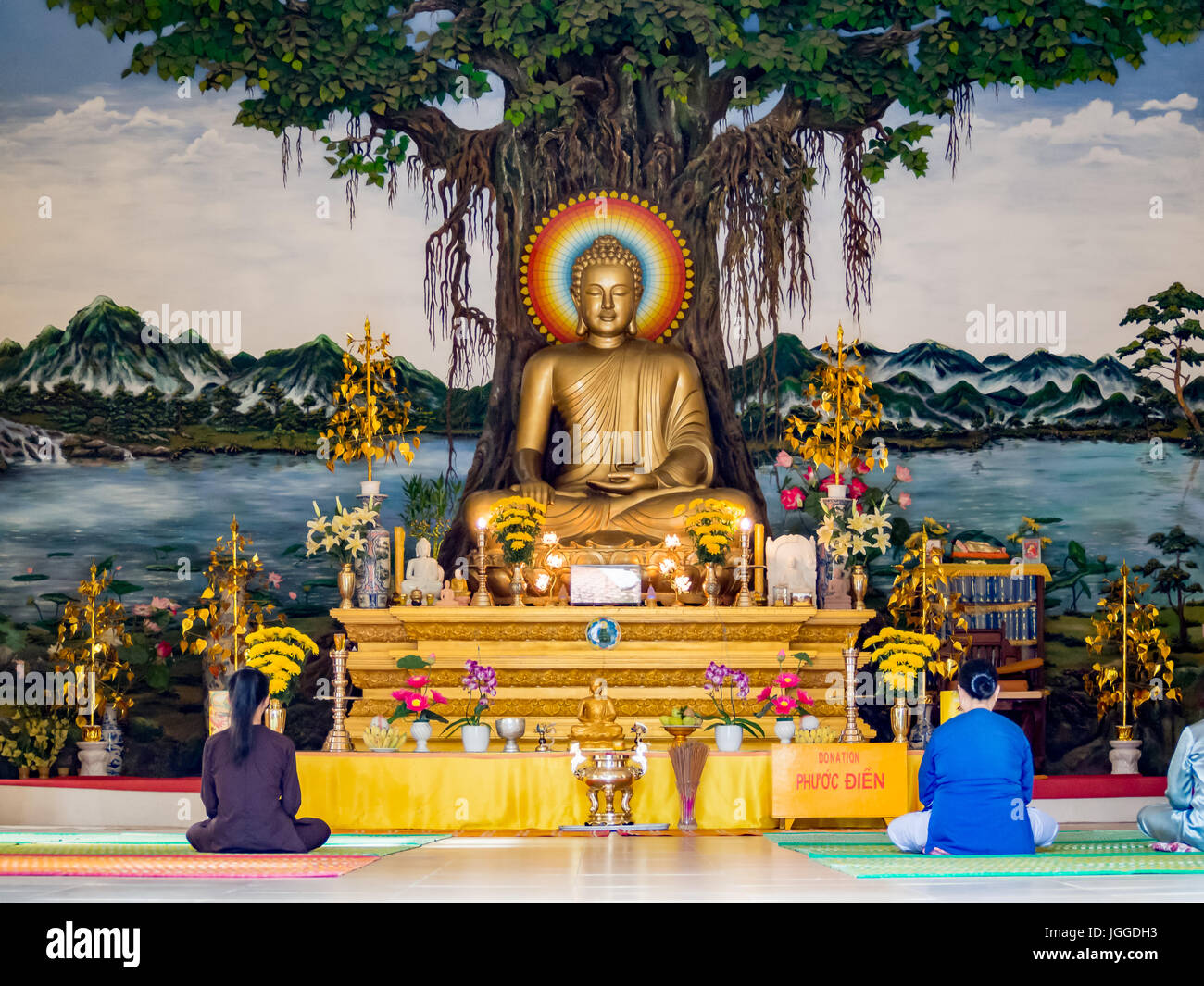 Prayer inside a Buddhist temple in Vietnam, Buddha statue worship in an ancient temple in Hoi An