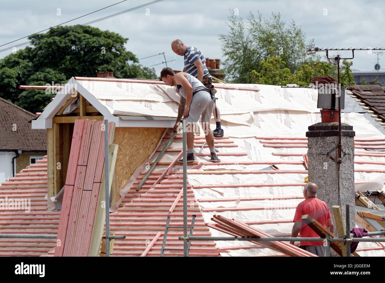 Builders constructing a loft extension on a suburban bungalow in Shepperton Surrey UK Stock Photo