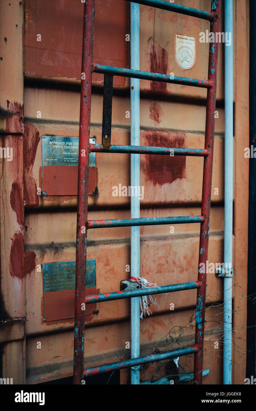 Steps on an old orange red shipping container. Stock Photo