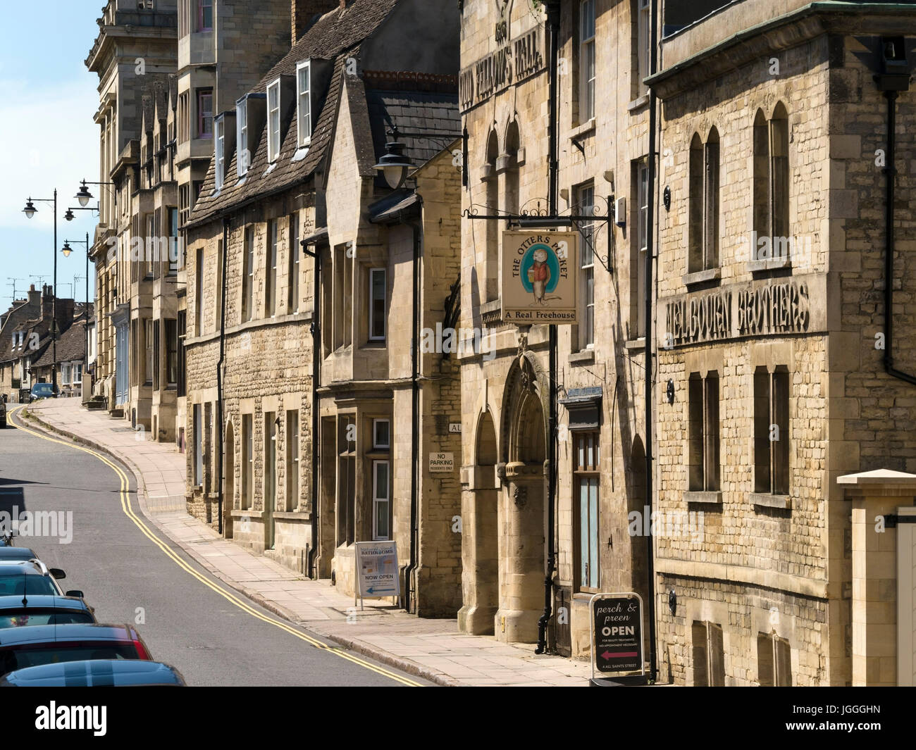 Row of sunlit old stone buildings, Otters Pocket public house and Melbourn Brothers Brewery, All Saints Street, Stamford, Lincolnshire, UK Stock Photo