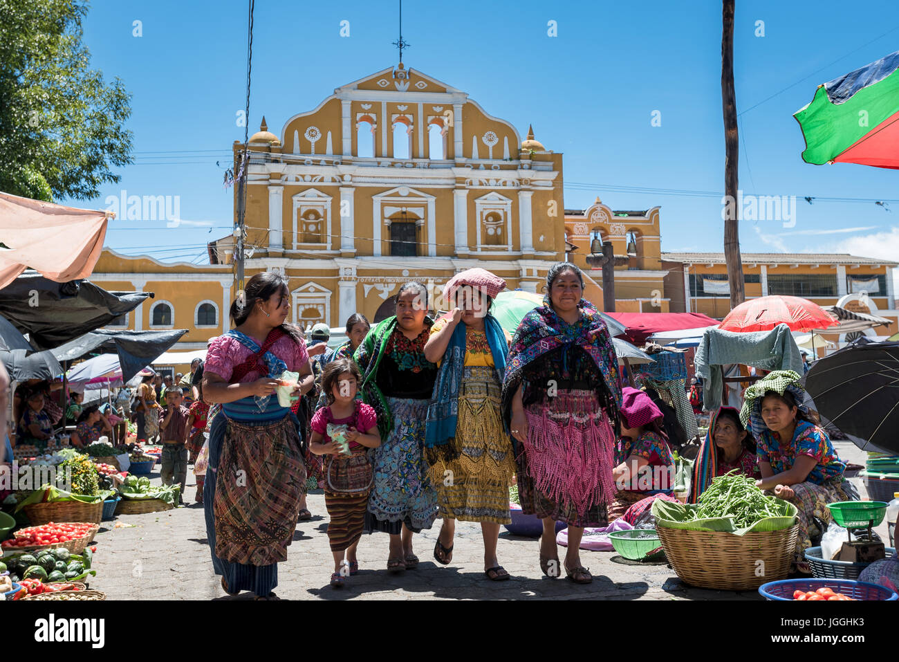 Several women of mixed ages in the typical native dress at the market in Guatemala Stock Photo