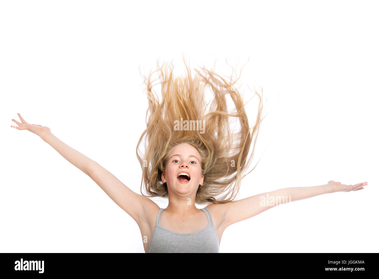 young teen girl with blond wavy hair up in the air against white studio  background Stock Photo - Alamy