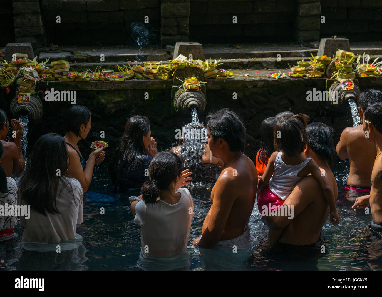 Worshipers taking a bath in the purifying pool at Tirta Empul temple, Bali island, Tampaksiring, Indonesia Stock Photo