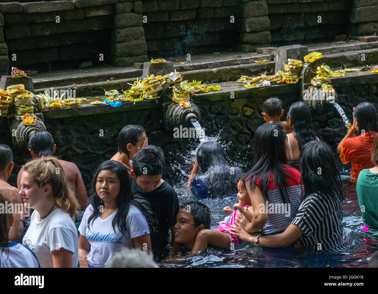 Worshipers taking a bath in the purifying pool at Tirta Empul temple, Bali island, Tampaksiring, Indonesia Stock Photo