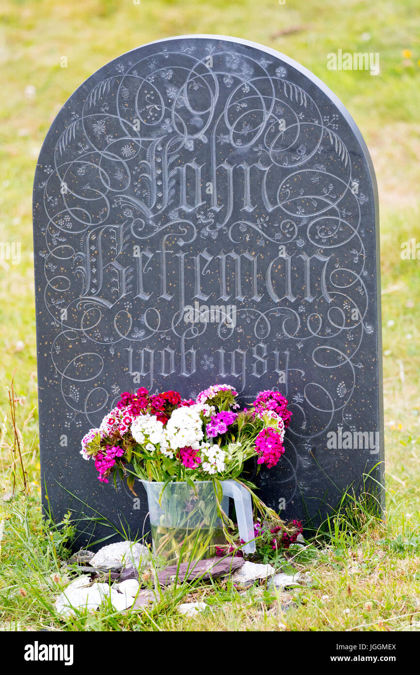 Sir John Betjeman's grave stone with flowers at the base at St Enadoc's chapel Stock Photo