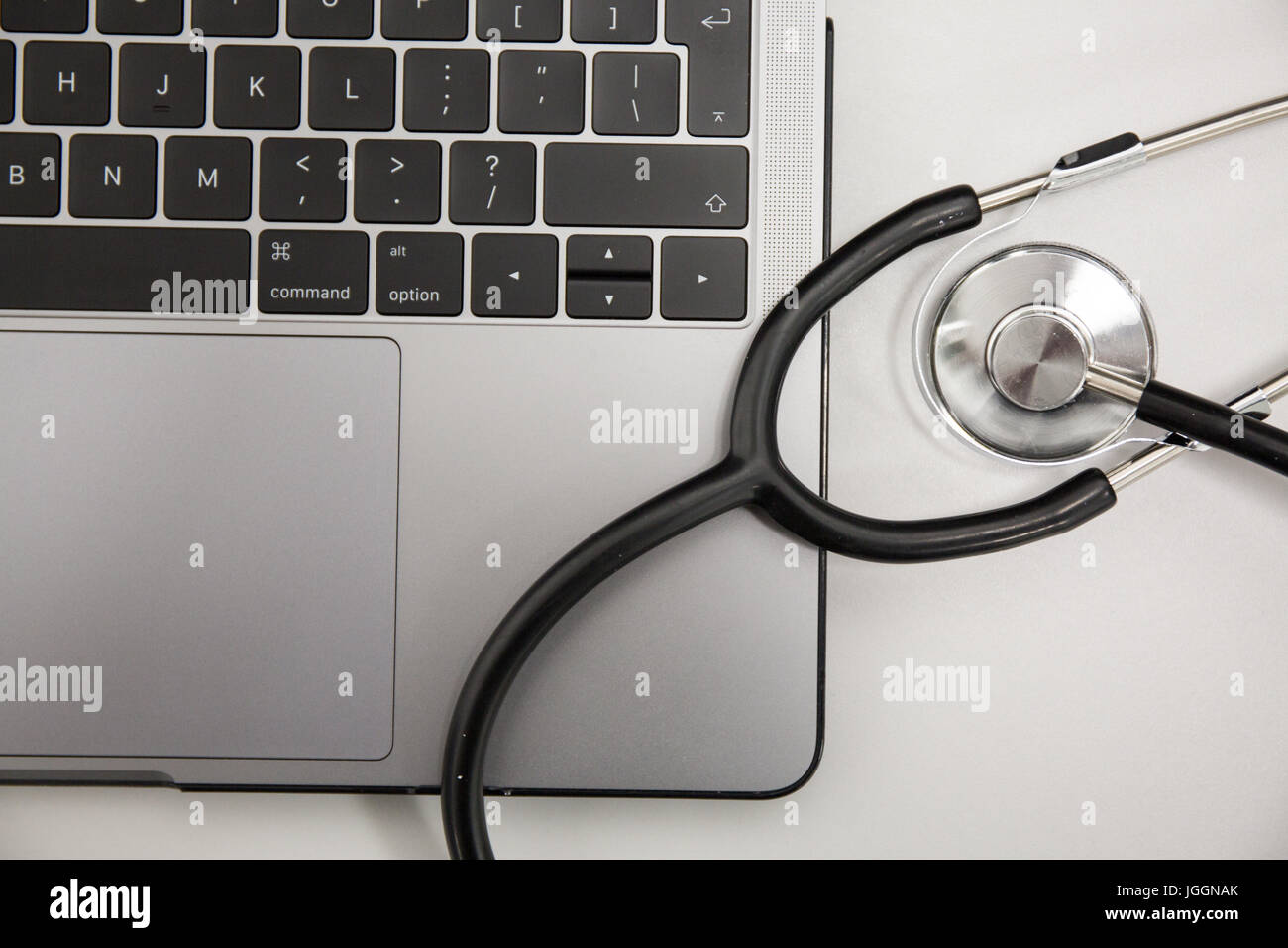 Doctors stethoscope resting on a laptop computer Stock Photo