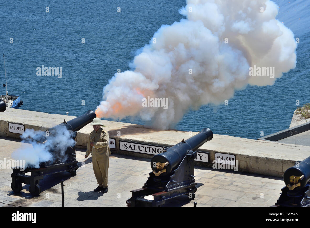 Re-enactment of colonial solider firing a cannon from a sea fort, Valletta Malta Stock Photo