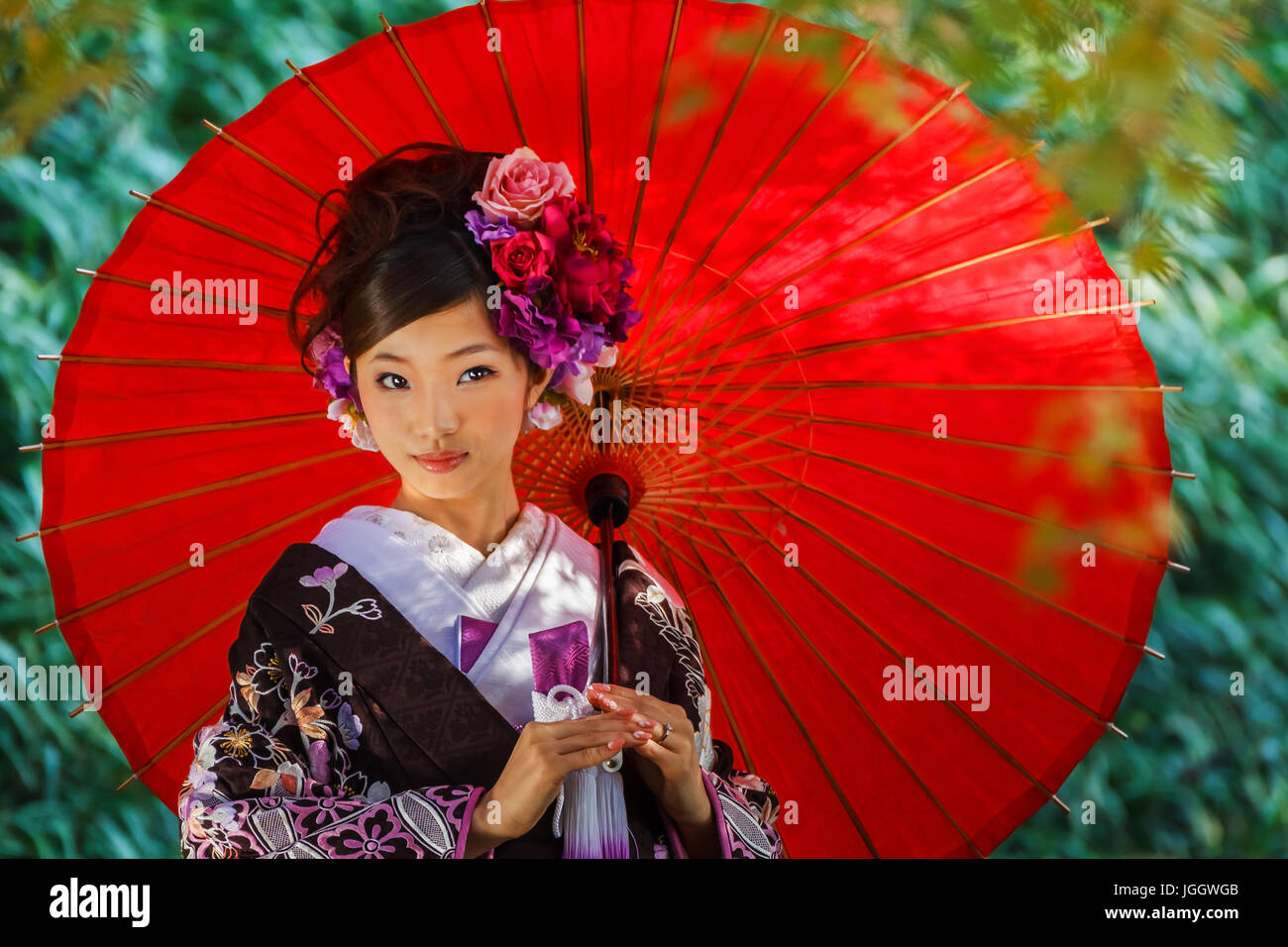 Japanese woman in a Traditional Kimono Dress with a Red Umbrella Stock Photo