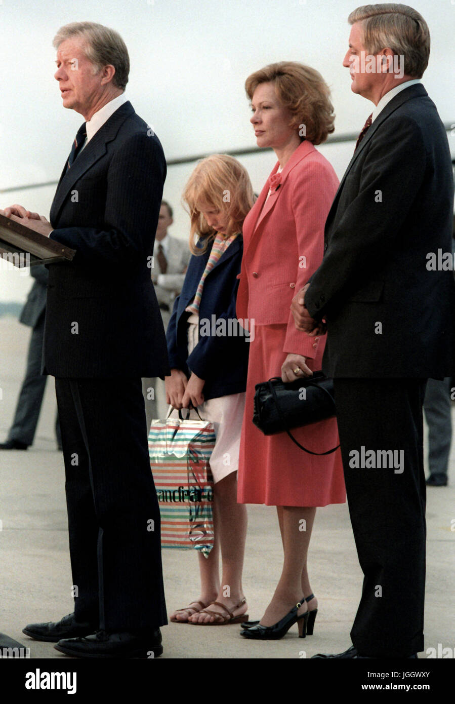 Rosalyn Carter, daughter Amy Carter and Vice President Walter Mondale listen as President Jimmy Carter speaks to a crowd upon his return from a European visit. Stock Photo