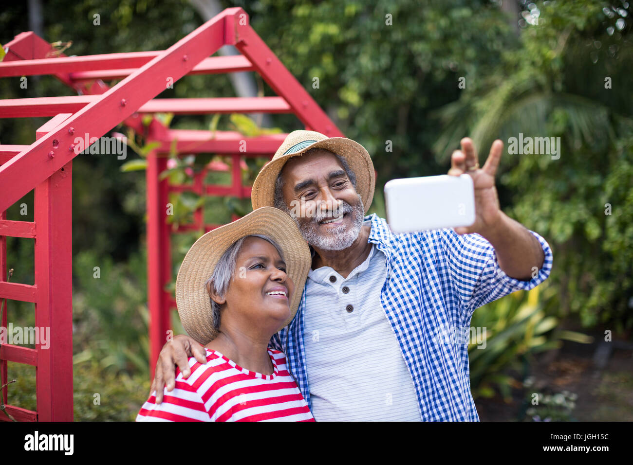 Happy senior couple taking selfie while standing in yard Stock Photo ...