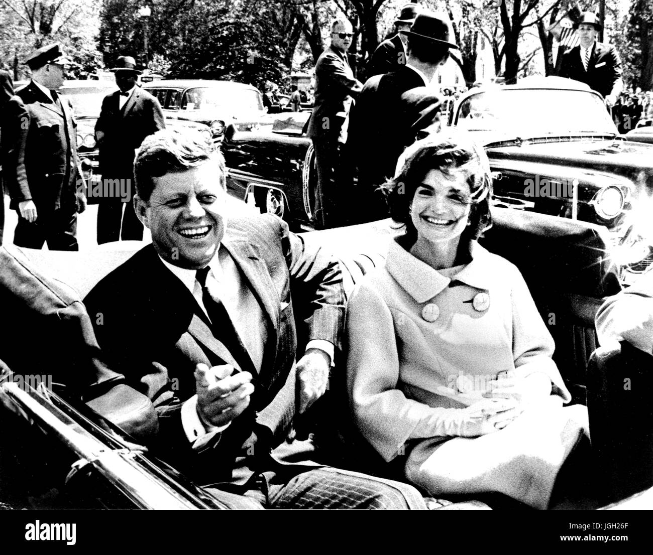 US President John F Kennedy and Jacqueline Kennedy smile while sitting in the back seat of an open car, John Kennedy pointing towards the camera, May 3, 1961. Courtesy Abbie Rowe/National Parks Service. Stock Photo