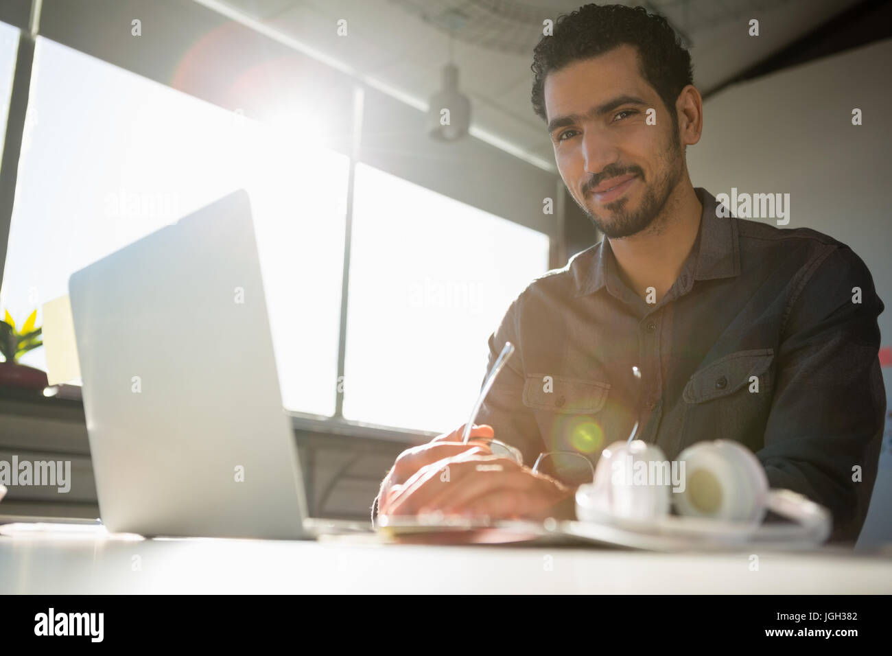 Low angle portrait of businessman using laptop at desk in office Stock ...
