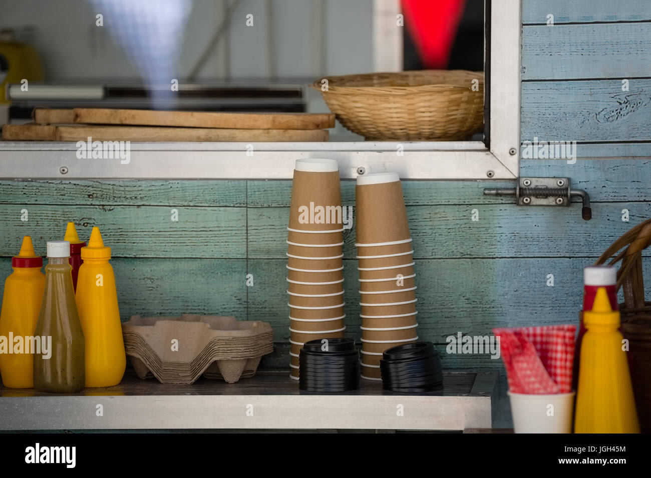 Cups and condiments on table by window at restaurant Stock Photo