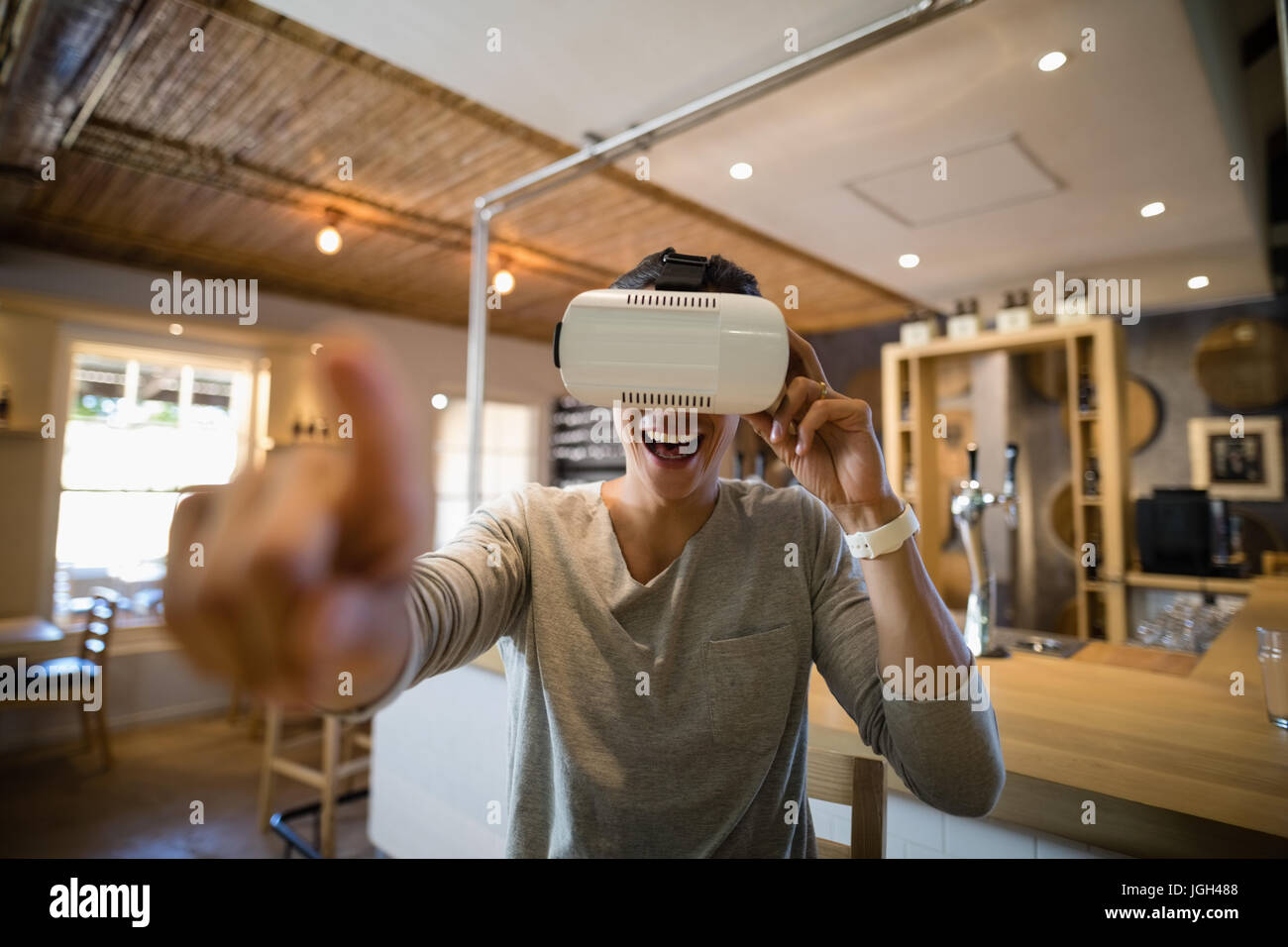 Smiling man using virtual reality headset in restaurant Stock Photo - Alamy