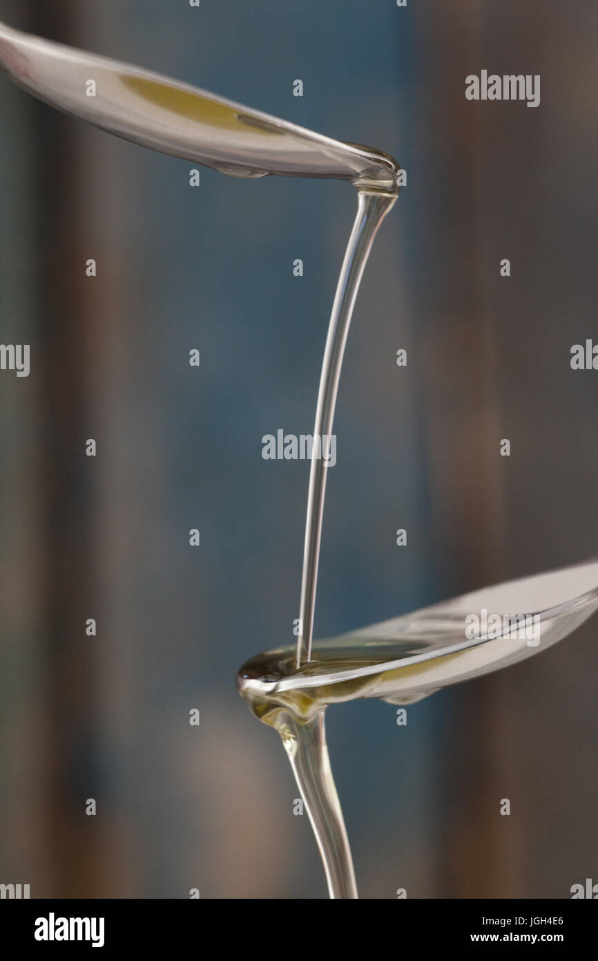 Close up of olive oil pouring on spoon Stock Photo