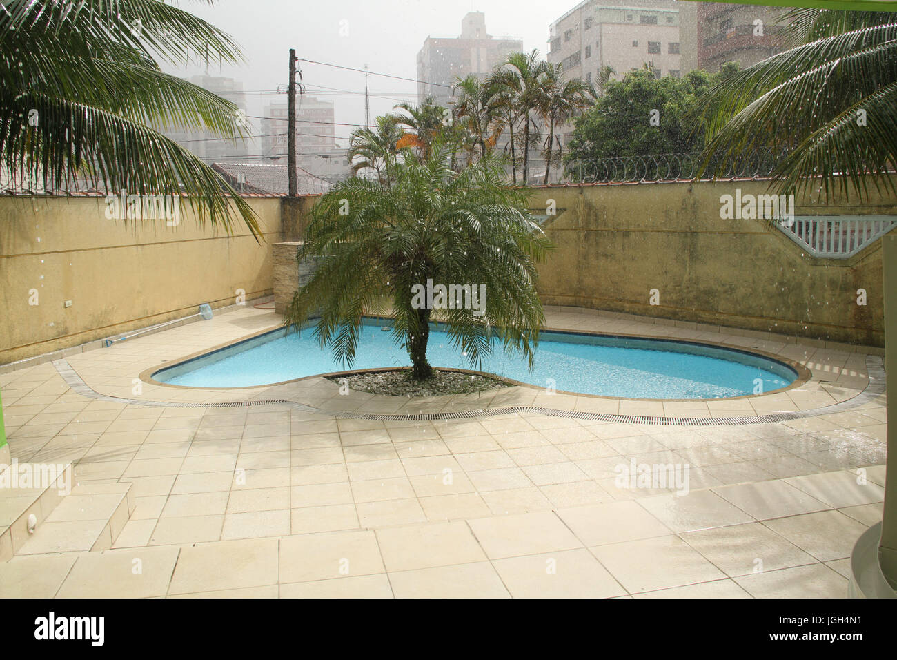 Sun with rain, swimming pool, 2017, Litoral Paulista, Praia Grande, São Paulo, Brazil. Stock Photo