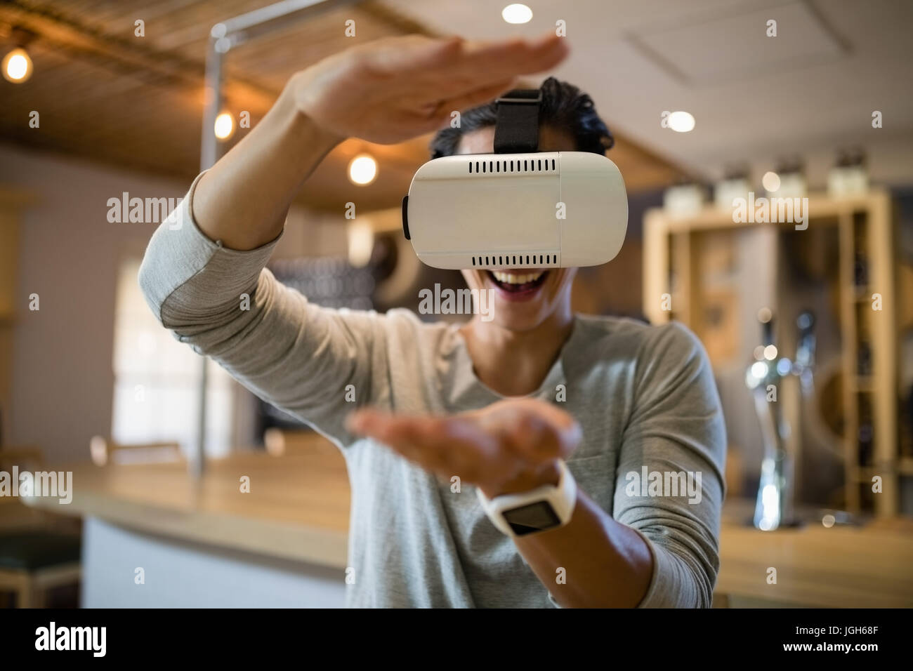 Smiling man using virtual reality headset in restaurant Stock Photo - Alamy