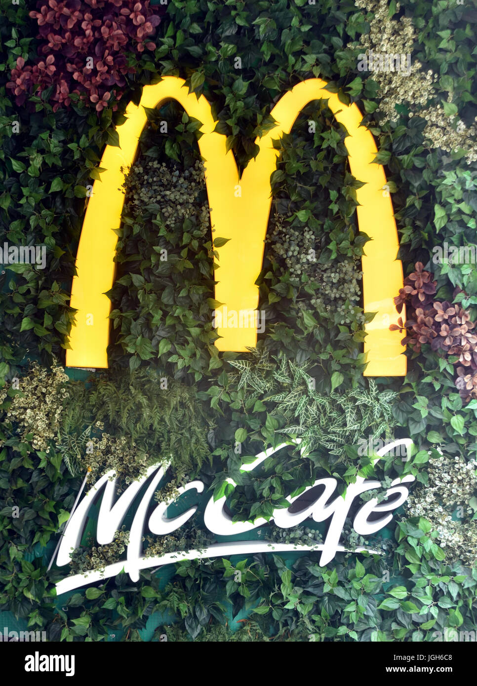 logos of McDonald's and McCafe in green mural Stock Photo
