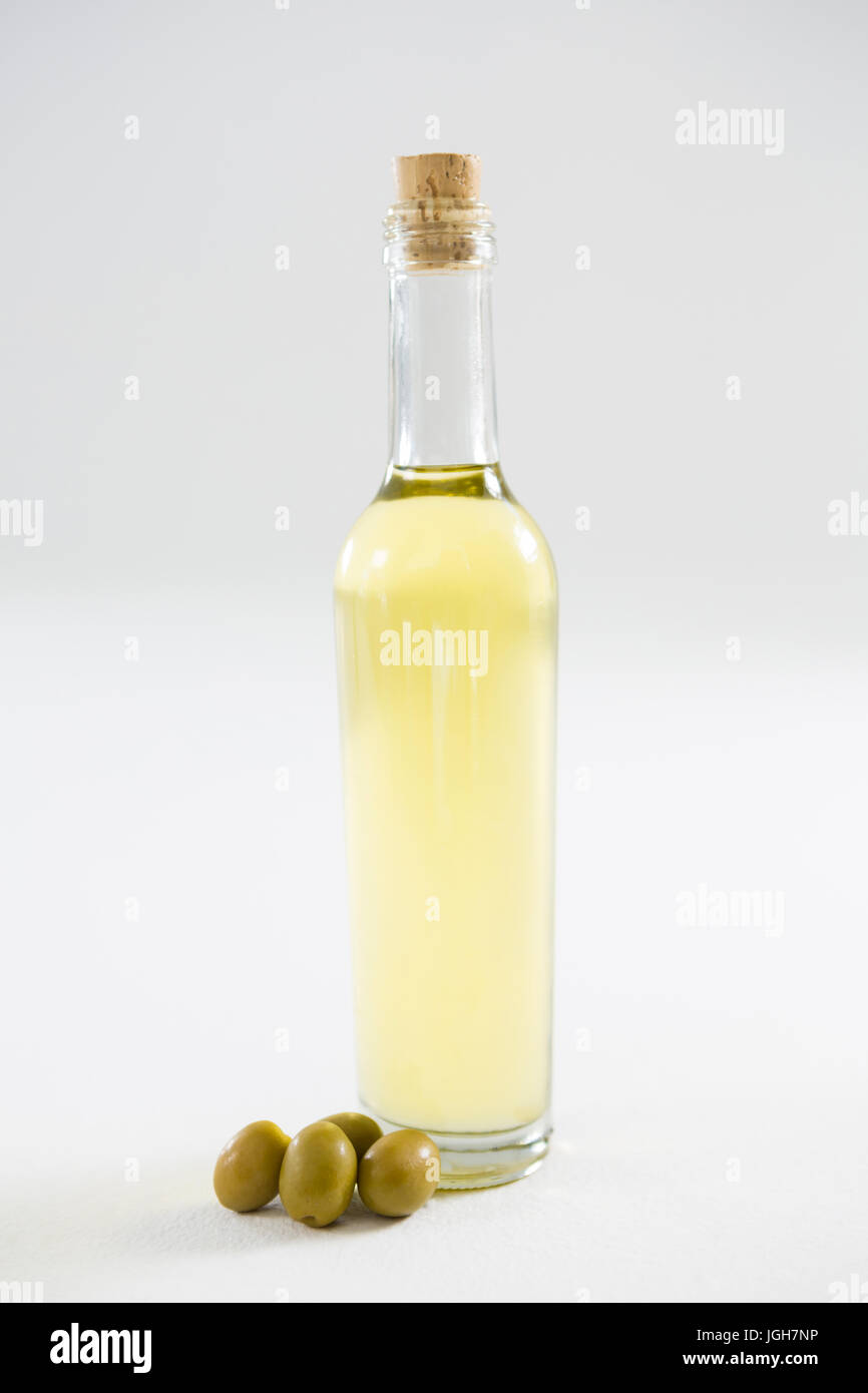 Green olive oil in bottle against white background Stock Photo - Alamy