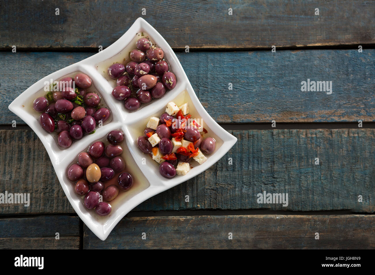 Pickled olives in platter on wooden table Stock Photo Alamy