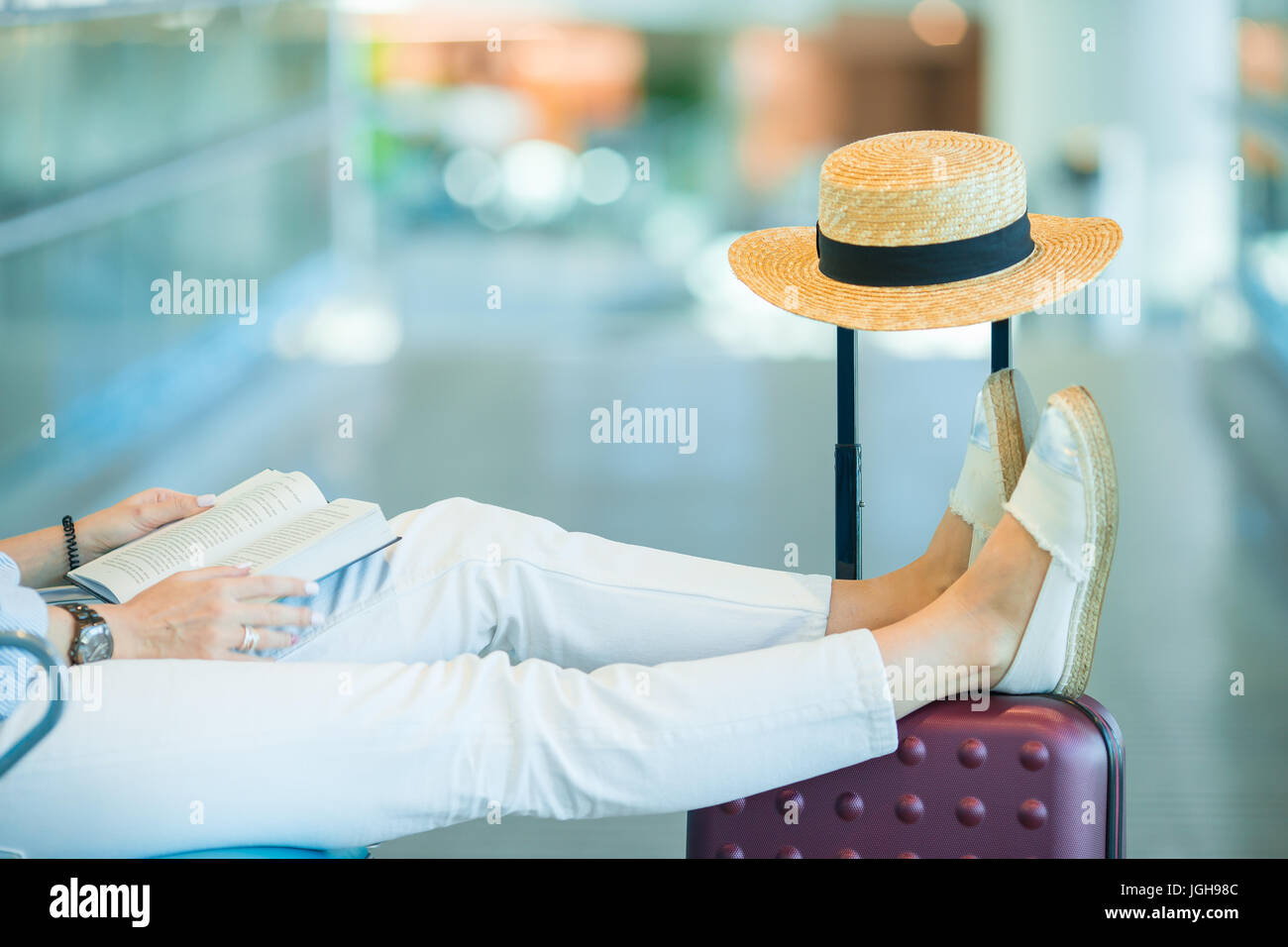 Young woman in an airport lounge waiting for landing Stock Photo - Alamy