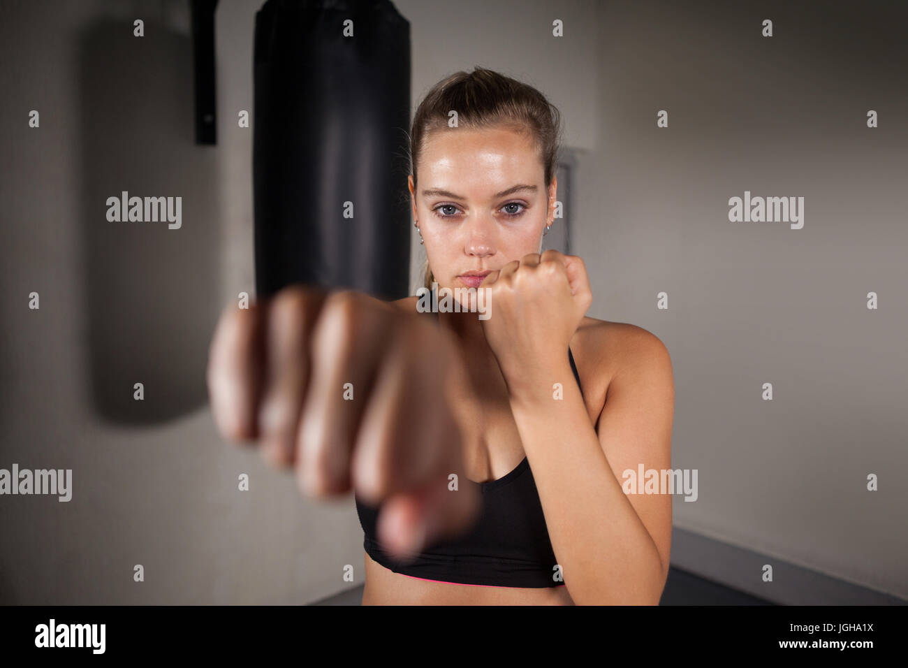 Portrait of female boxer practicing boxing in fitness studio Stock Photo