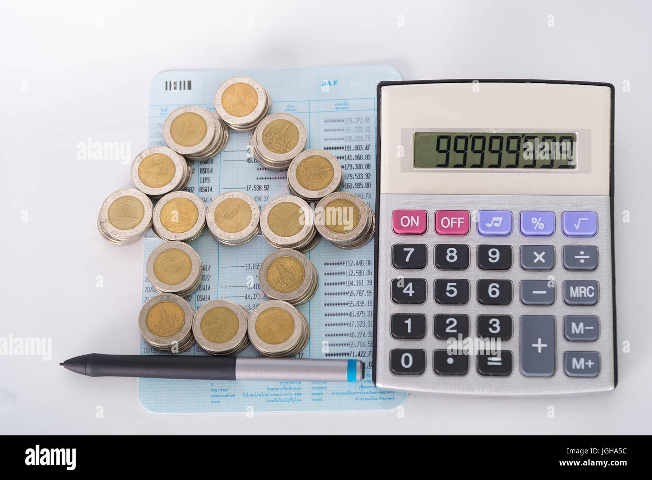Coin Stack Arithmetic Program Stack of coins as house shape and calculator on the account book on ...