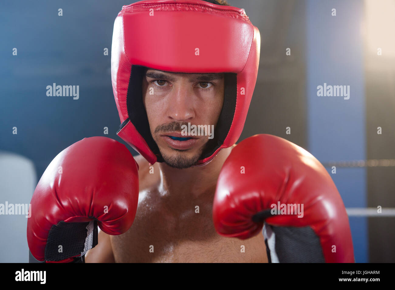 Closeup portrait of confident male boxer wearing red headgear and