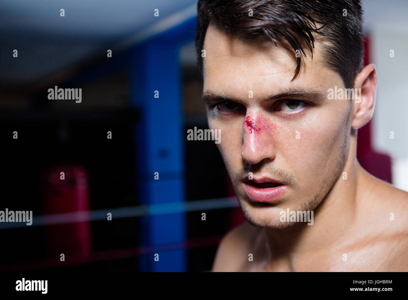 Close-up portrait of young male boxer with bleeding nose at fitness studio Stock Photo
