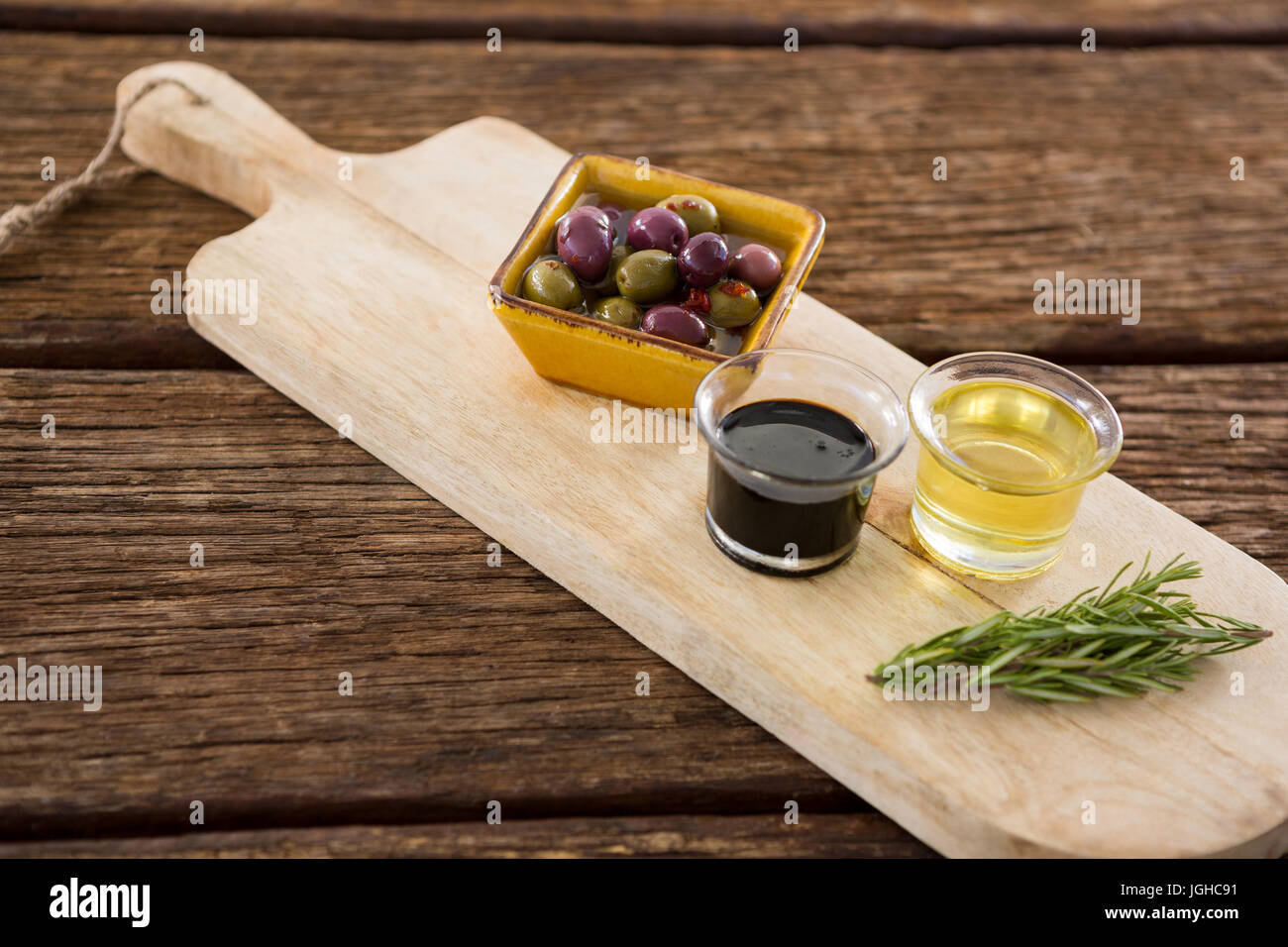 Rosemary olive oil balsamic vinegar wooden tray hires stock