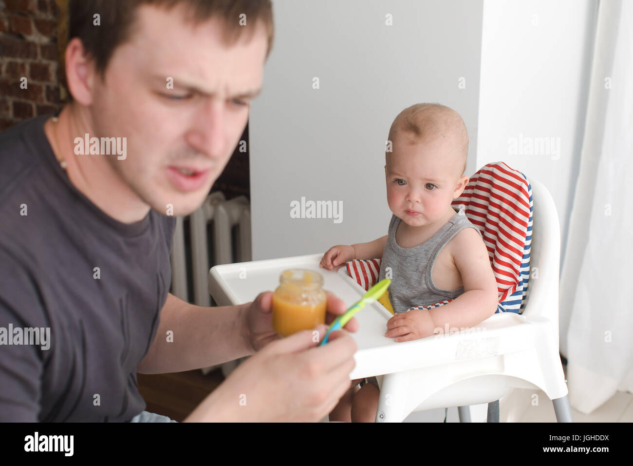 Father feeding infant son Stock Photo