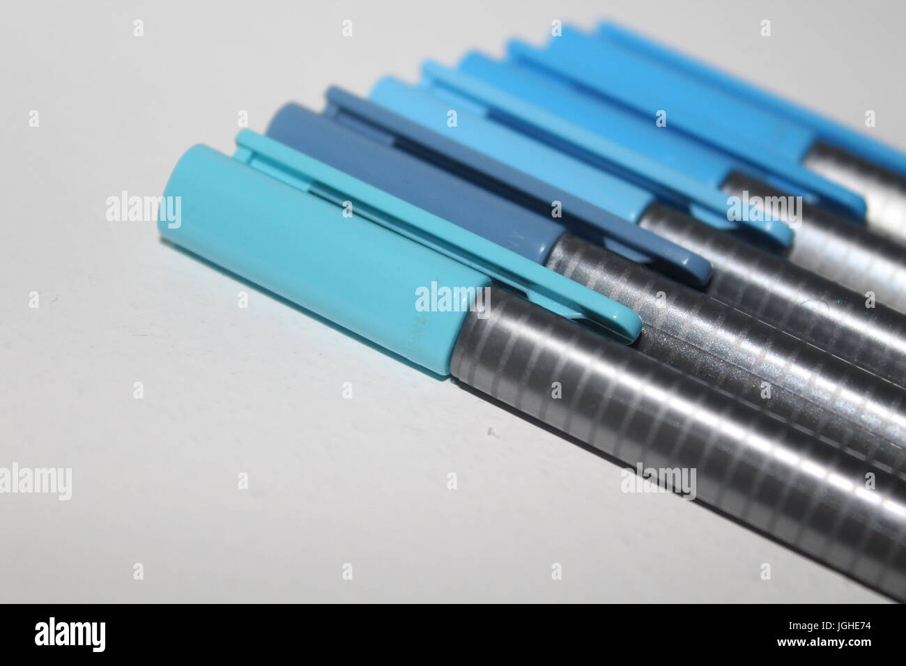 A row of pens in different shades of blue Stock Photo