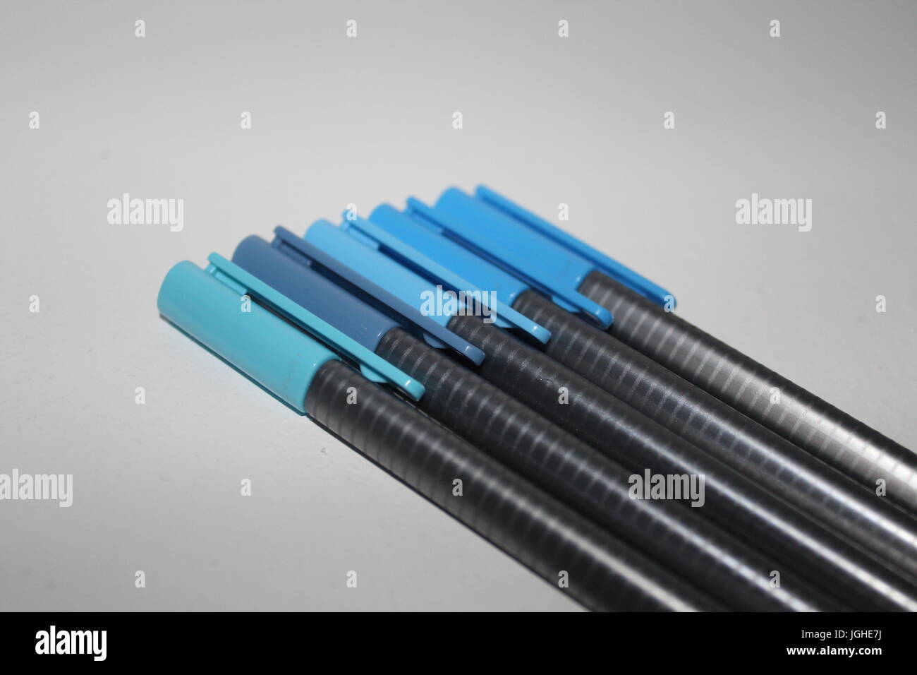 A row of pens in different shades of blue Stock Photo