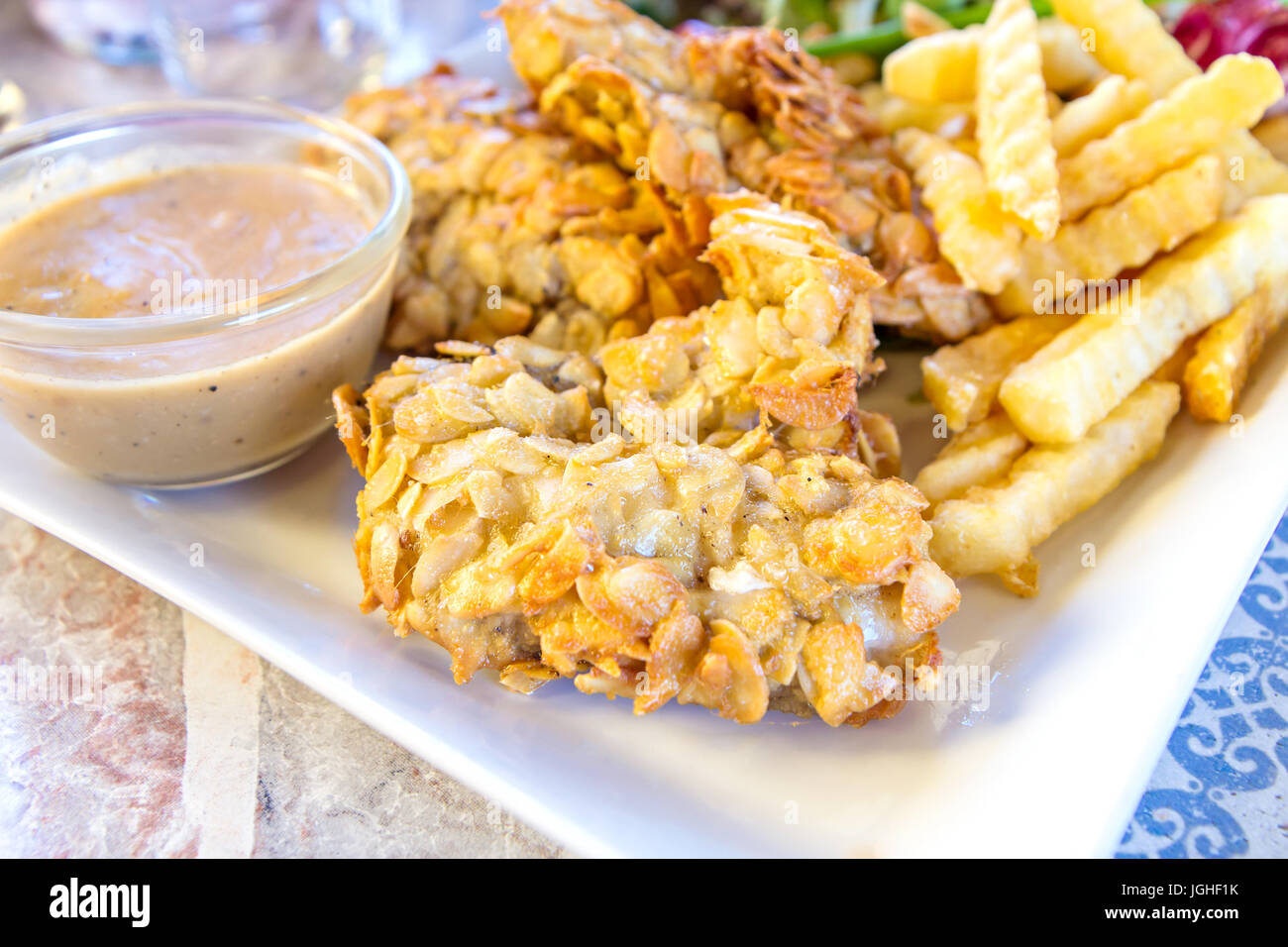 deepfried fish steaks with almond flakes and friend fried Stock Photo