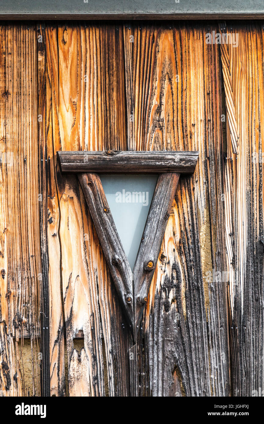 Old style traditional wooden window in triangular shape in wooden wall ...
