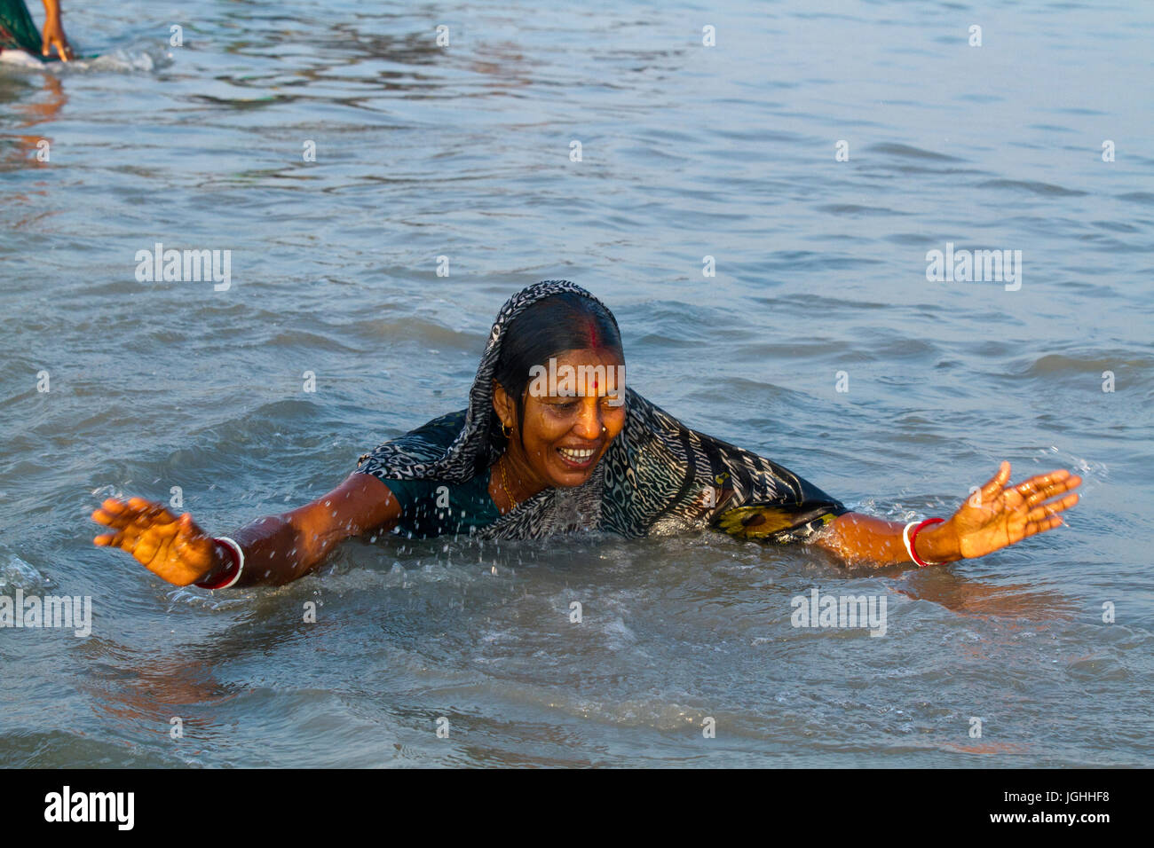 A woman from the Hindu community bathes at the Bay of Bengal during the Rash Mela at Dublarchar in the Eastern Division of Sundarbans forest. Thousand Stock Photo