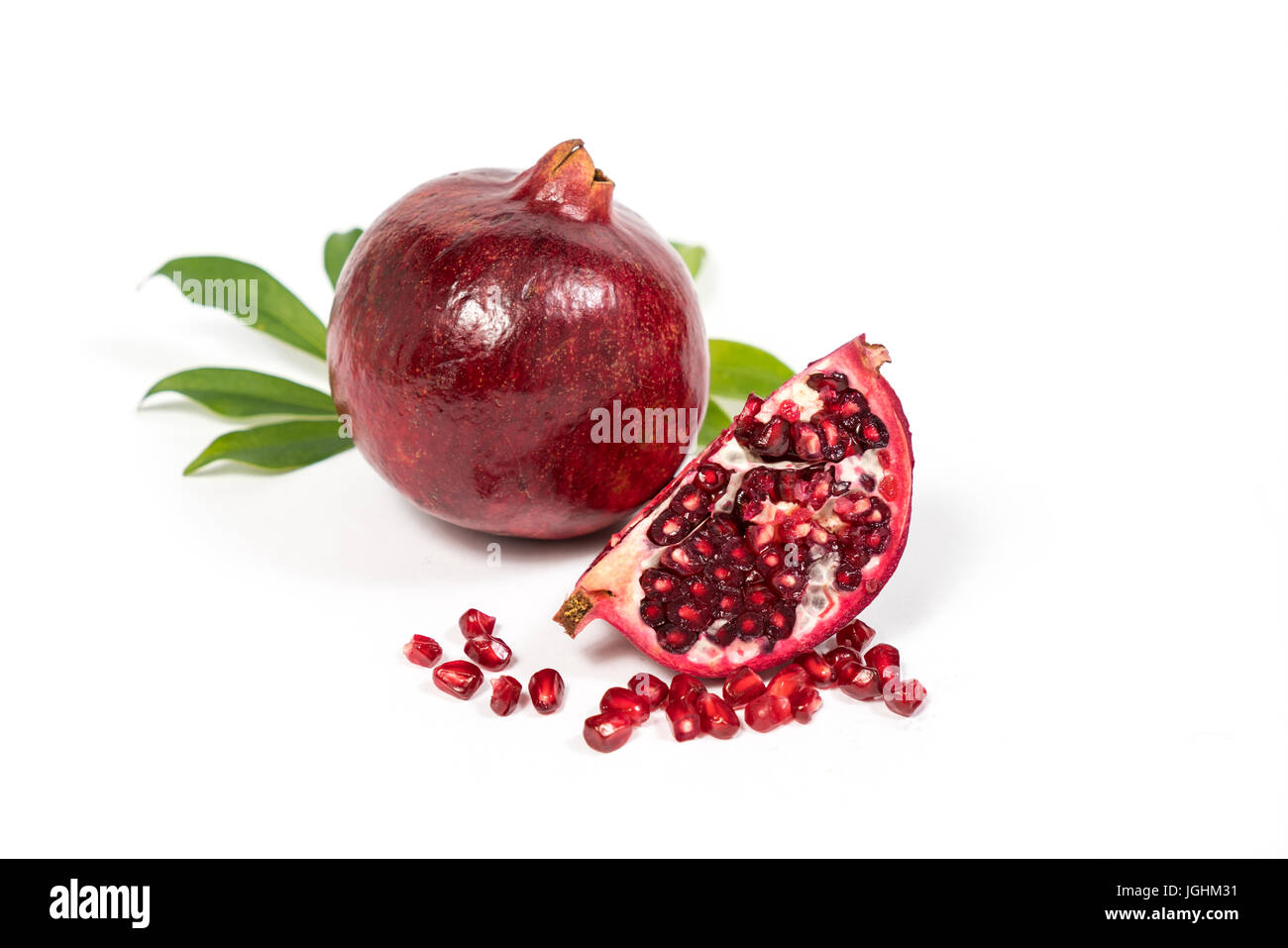 Fresh Pomegranate sliced with seeds on isolated white background Stock Photo