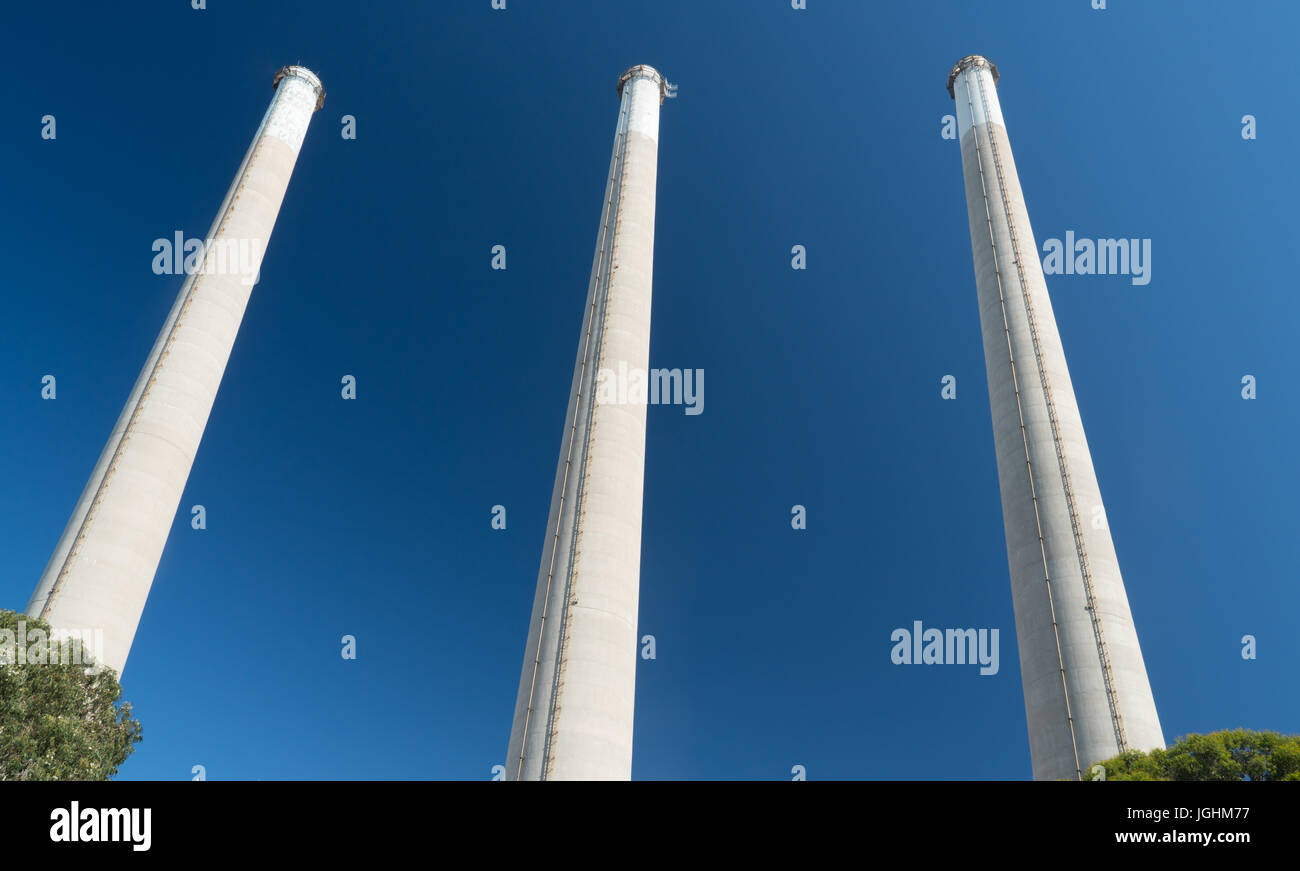 Industrial factory smoke stacks against a blue sky Stock Photo
