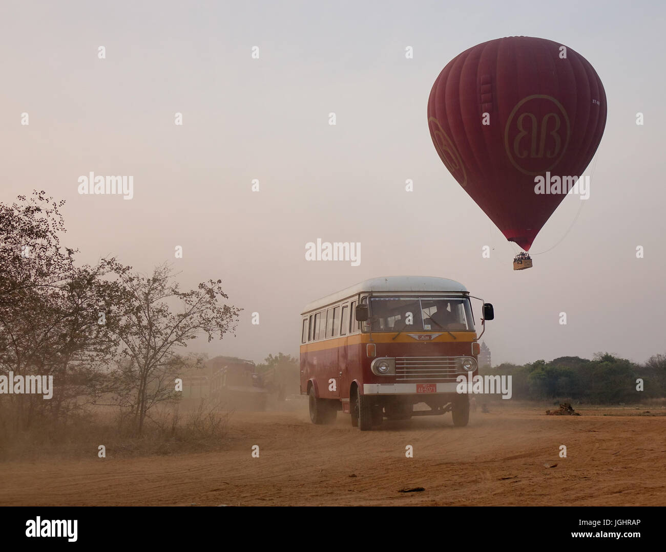 Bagan, Myanmar - Feb 20, 2016. An old bus carrying tourists with the balloon background in Bagan, Myanmar. Ballooning over Bagan is one of the most me Stock Photo