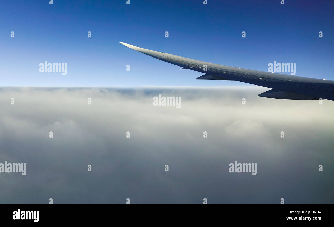 Wing of an airplane flying above the beautiful cloudy sky Stock Photo ...