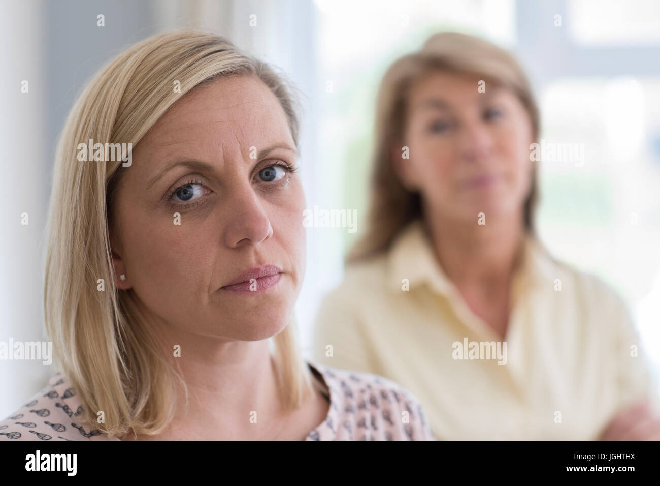 Mature Mother Concerned About Adult Daughter At Home Stock Photo
