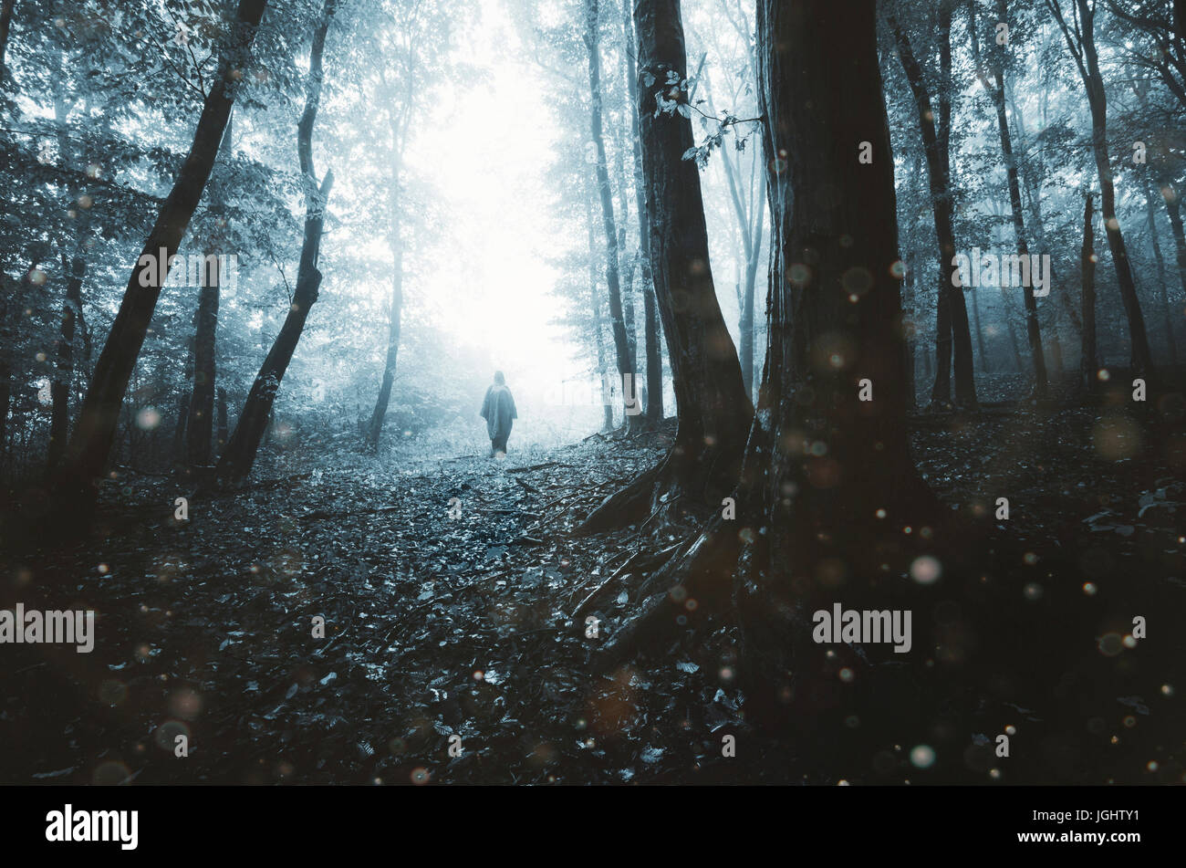 dark scary forest with mysterious ghostly figure on Halloween night Stock Photo