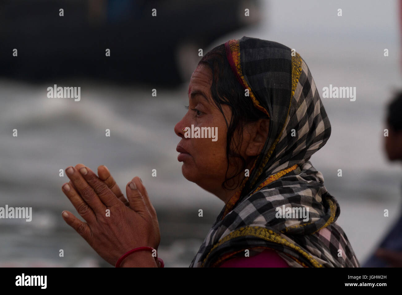 A woman from the Hindu community offers Morning Prayer at the shore of the Bay of Bengal during the Rash Mela at Dublarchar in the Eastern Division of Stock Photo
