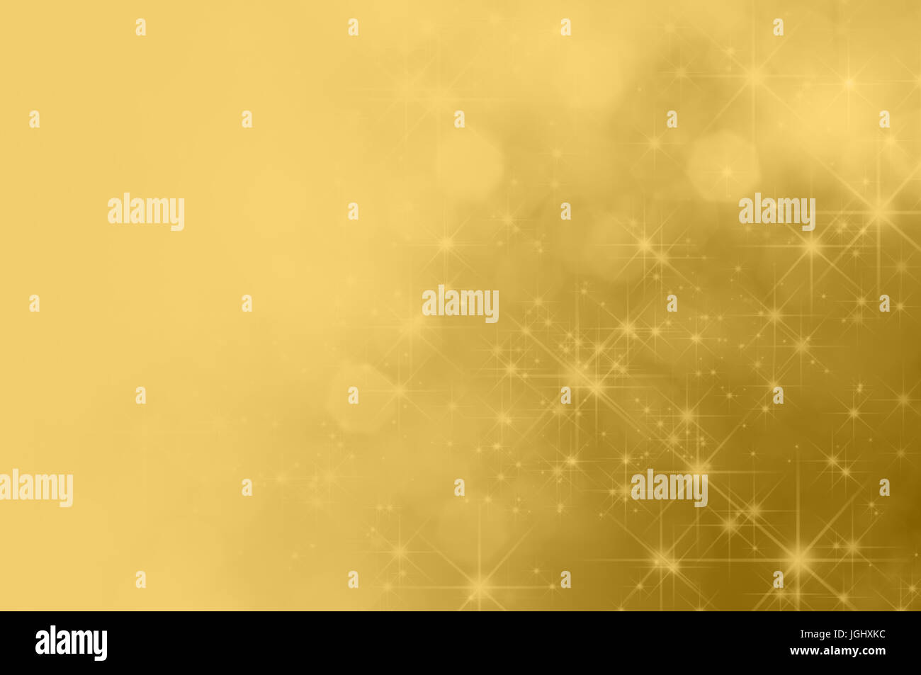 A festive gold background with bokeh and sparkling stars, fading towards solid colour copy space on the left side. Stock Photo