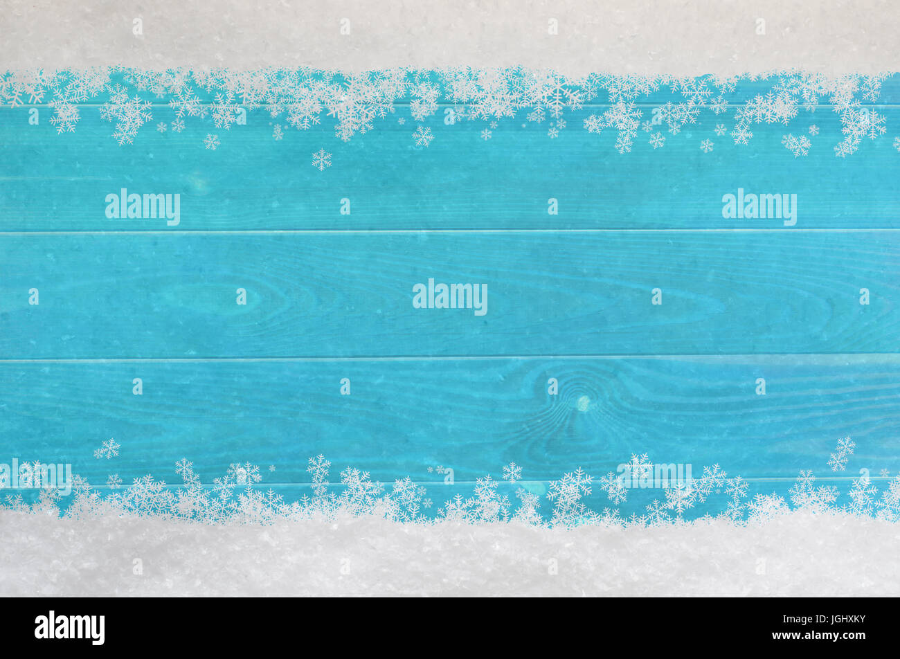 Christmas snow and snowflakes border at top and bottom of light, bright blue wood planking. Stock Photo