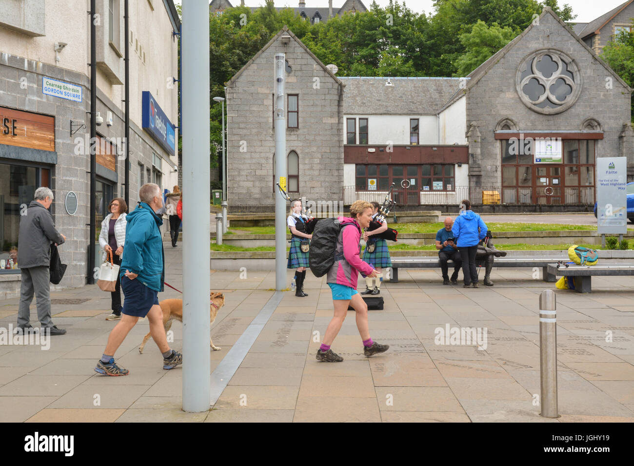 West Highland Way, Scotland, uk - two walkers and their dog crossing the finishing line in Fort William Stock Photo