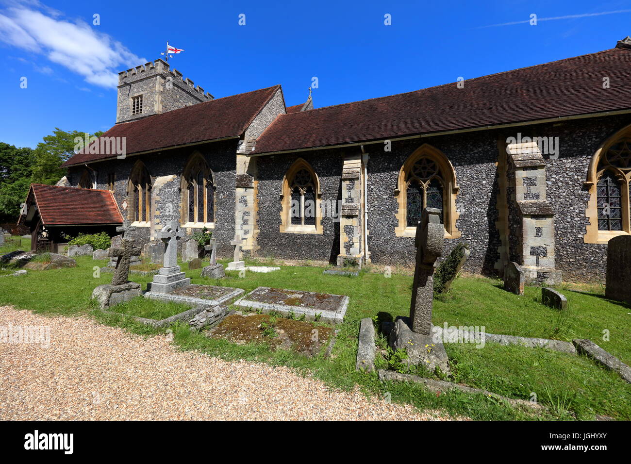 The West side of the village church in Sonning on Thames showing the west entrance amidst the headstones in the neatly kept churchyard. Stock Photo