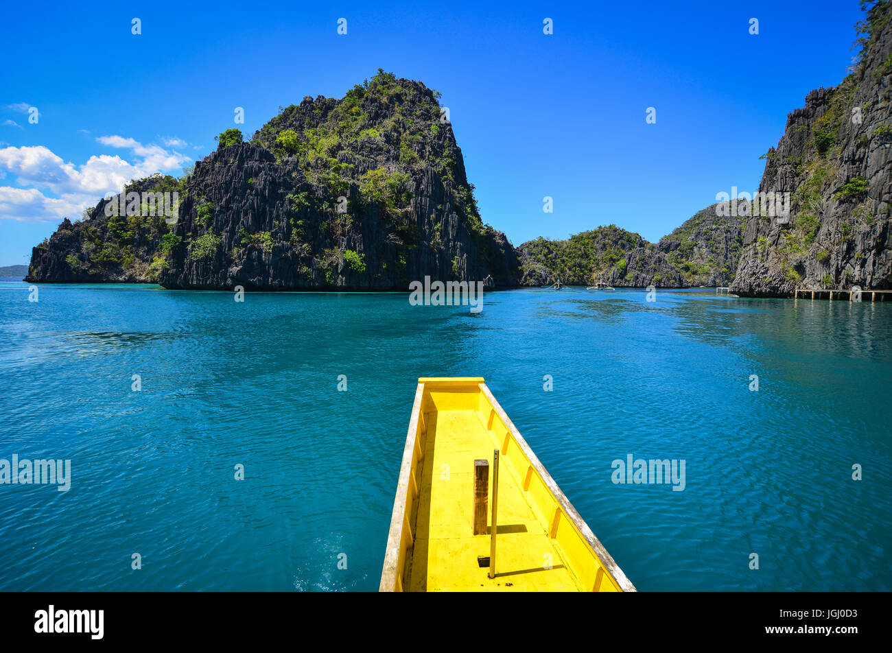 A yellow wooden boat on the tropical sea with turquoise water at sunny ...